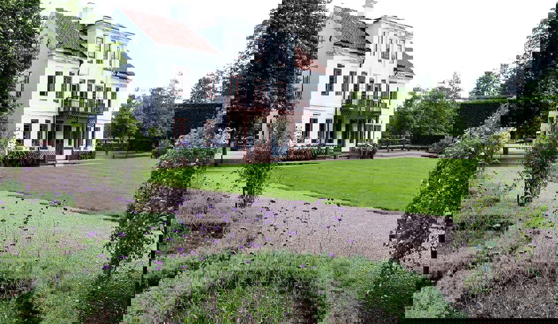 Frederiksdal ses med haven i forgrunden.