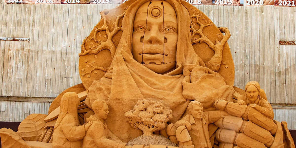 Moder Jord sandskulptur från Hundested Sandskulptur 22 med intrikata detaljer och modernt tema.