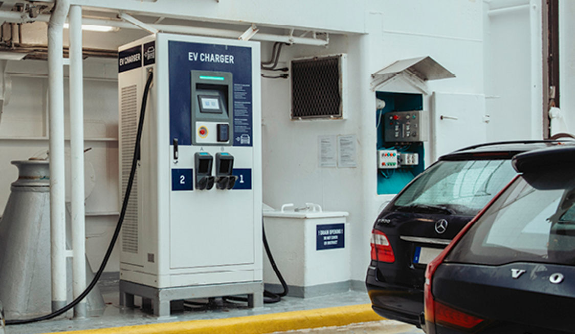 Laddstation för elbilar ombord på färja med svarta bilar parkerade bredvid, vid EV-laddare V2.