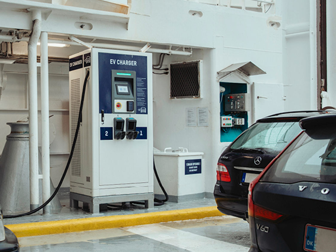 Laddstation för elbilar ombord på färja med svarta bilar parkerade bredvid, vid EV-laddare V2.
