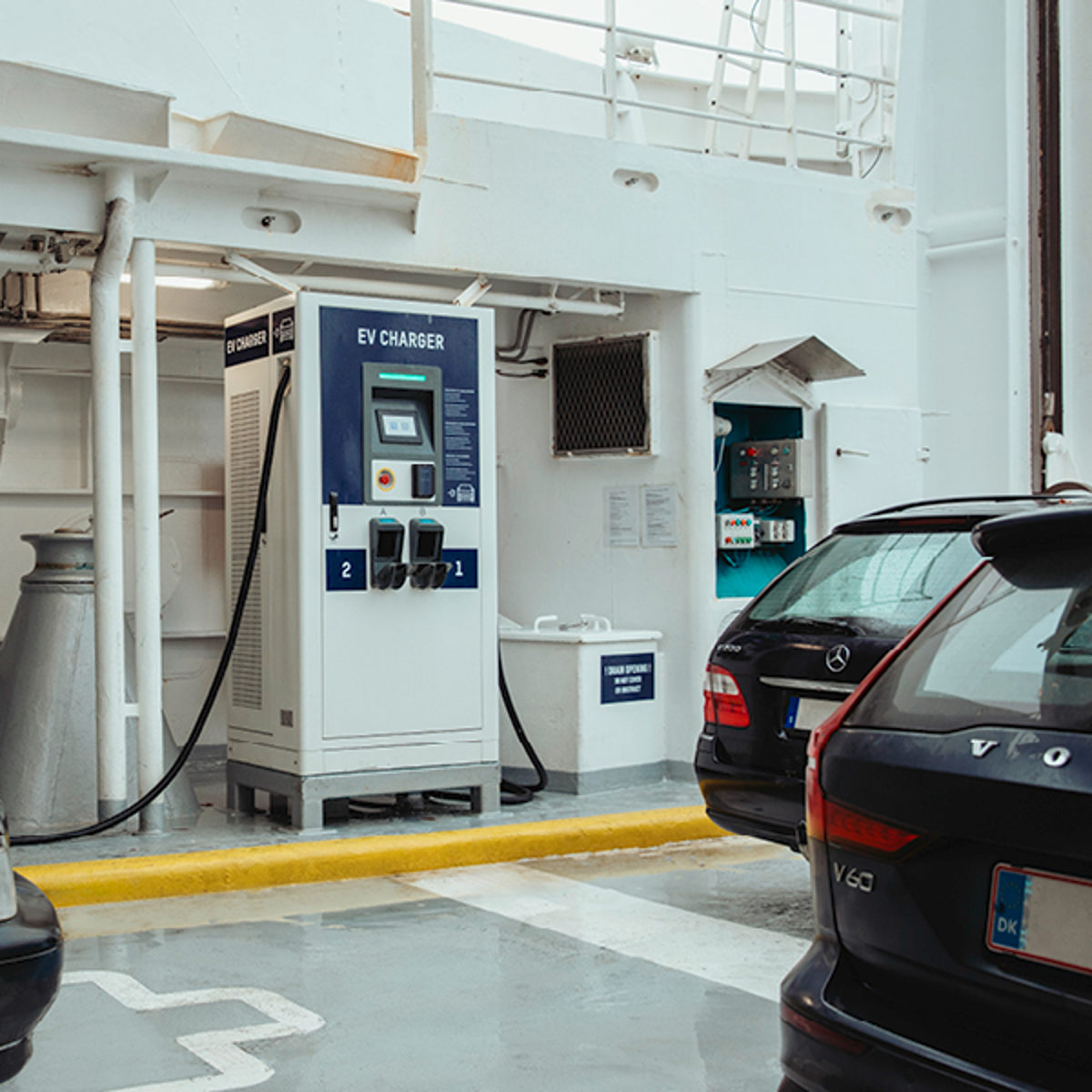 Laddstation för elbilar ombord på färja med svarta bilar parkerade bredvid, vid EV-laddare V2.