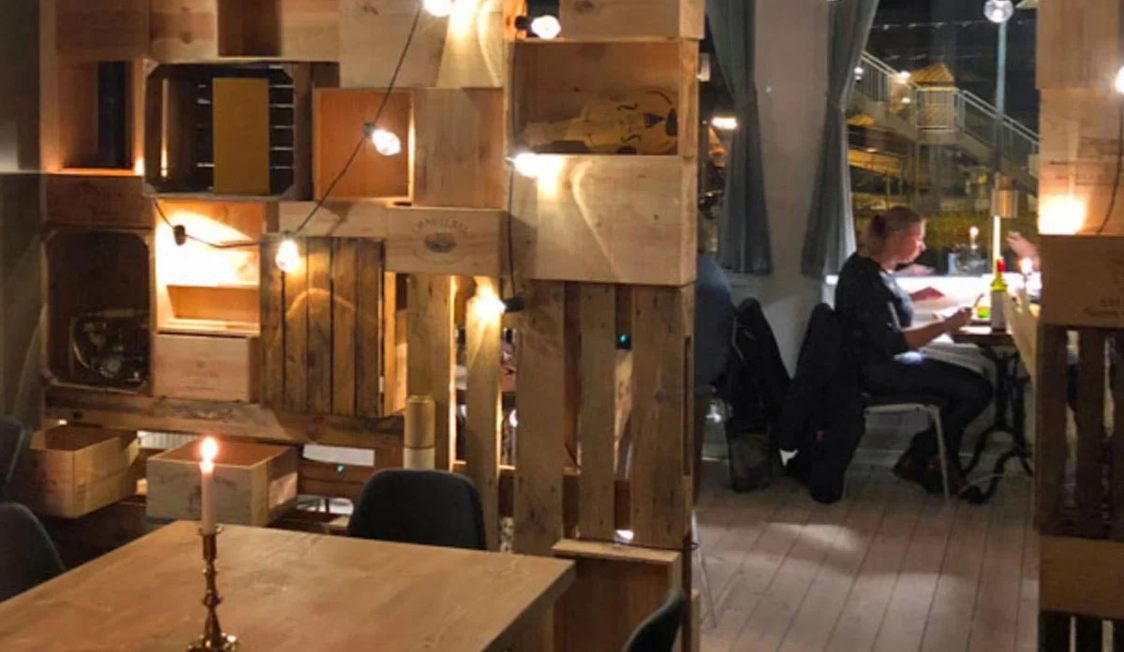 Inredningen på restaurang i Helsingör med träpaneler och belysning, ett bord i förgrunden.