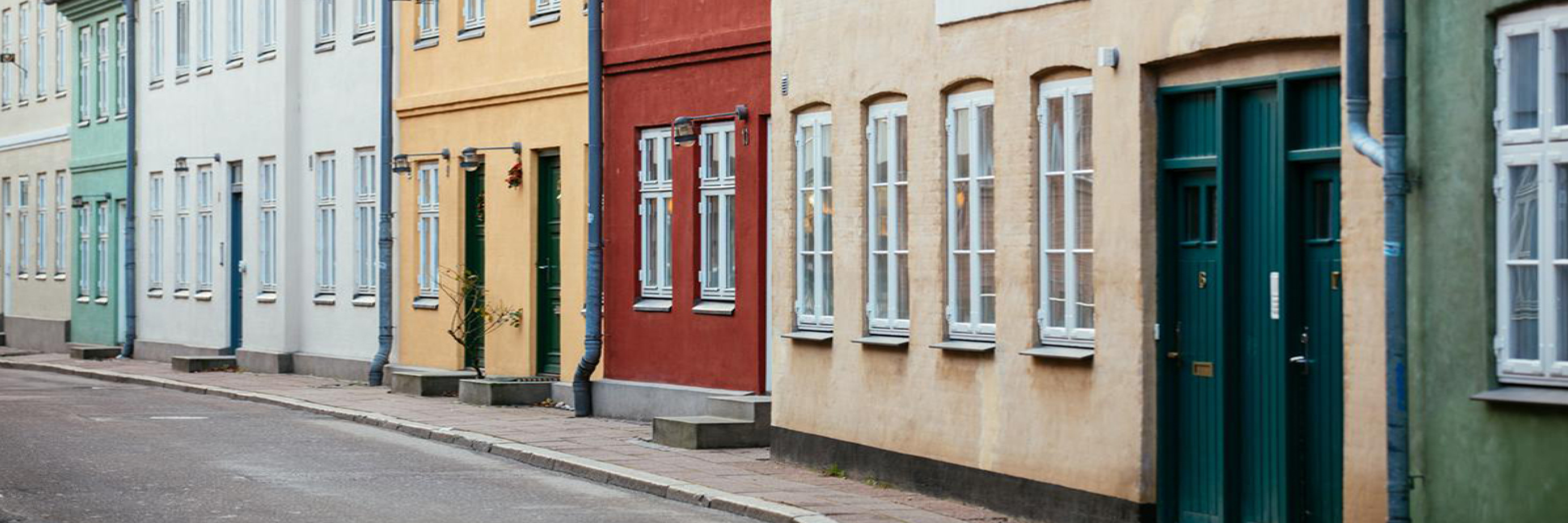 Färgglada fasader på rad längs en tom gata i Helsingör, del av Helsingör Kultur Banner.