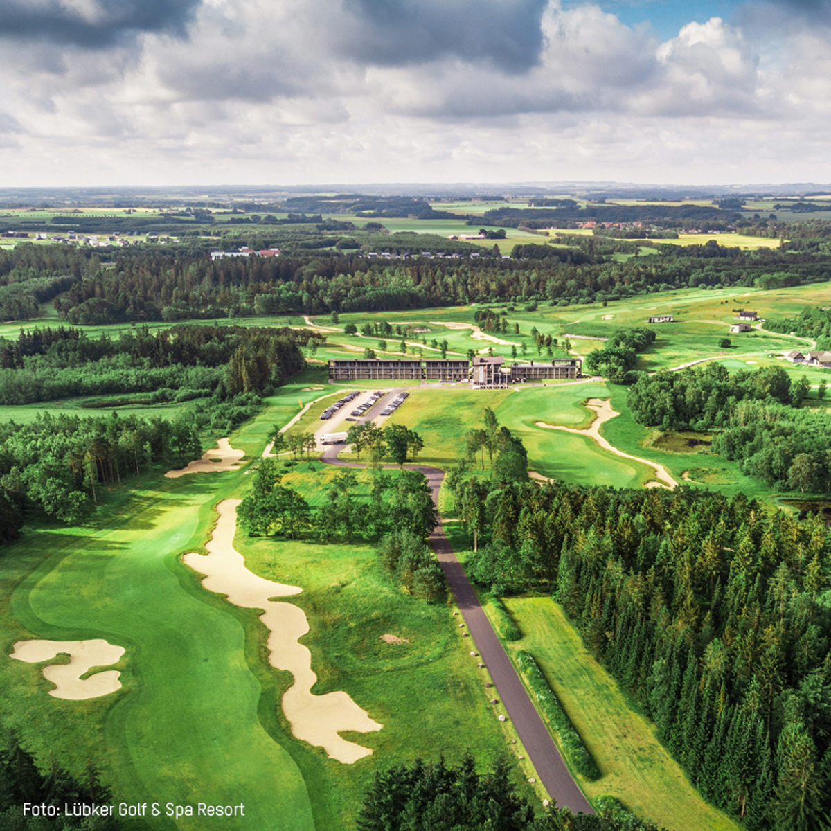 Lübker Golf & Spa Resort golfbane set fra luften omgivet af grønne skove og landskaber.