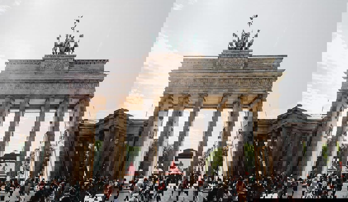 Berlin Brandenburg i dagsljus med terminalbyggnader och flygplatsområde i förgrunden, sett från ovan.
