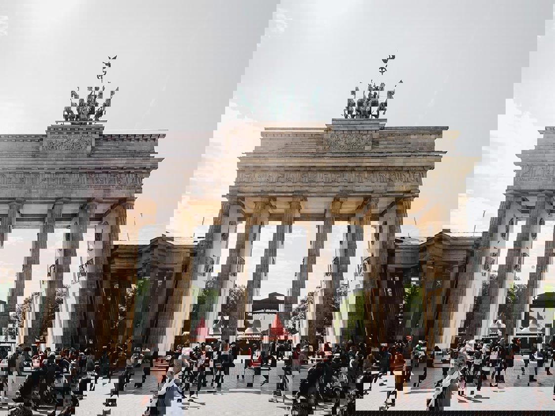 Berlin Brandenburg i dagsljus med terminalbyggnader och flygplatsområde i förgrunden, sett från ovan.