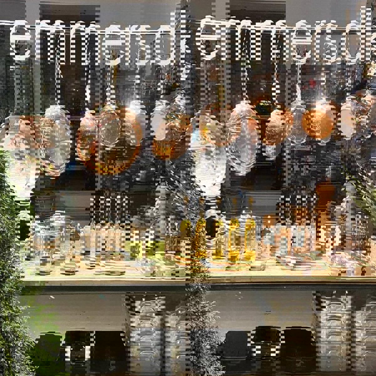 Genom ett skyltfönster kan man se kastruller och annan köksutrustning.