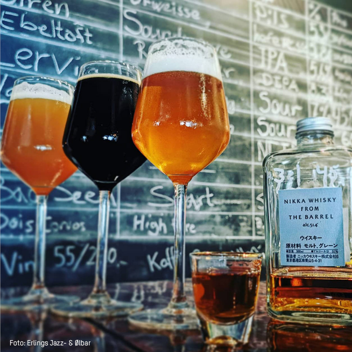 Tre øl i vinglas ved en tavle, ved siden af en flaske Nikka whisky i baggrunden.