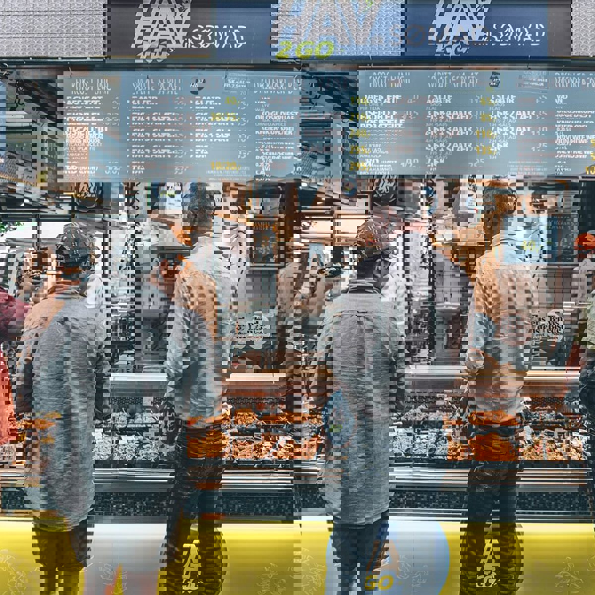 Två personer köper delikatesser vid en disk i Torvehallerne.