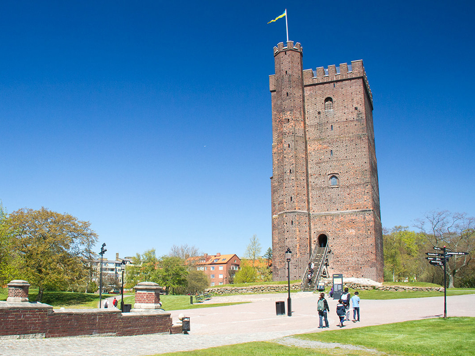 Middelaldertårn i rød mursten i Helsingborg set i solrigt vejr mod en klar blå himmel.