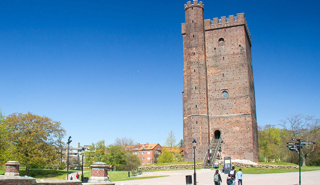 Middelaldertårn i rød mursten i Helsingborg set i solrigt vejr mod en klar blå himmel.