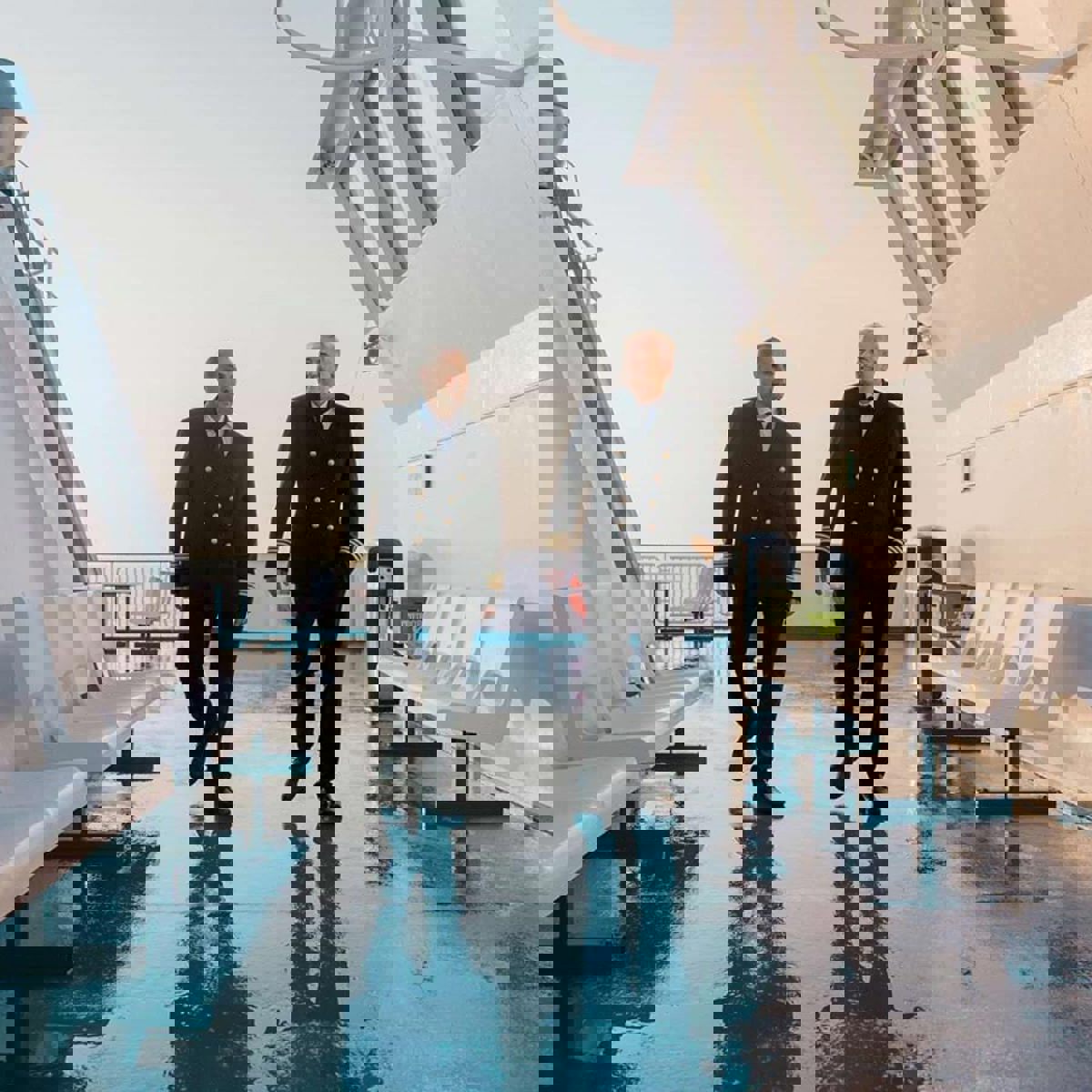 To kaptejner ses gående på dækket på Øresundlinjen i solskinsvejr.