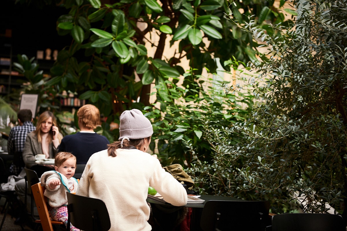  En mamma och ett barn sitter vid ett cafébord inne på Glyptoteket.