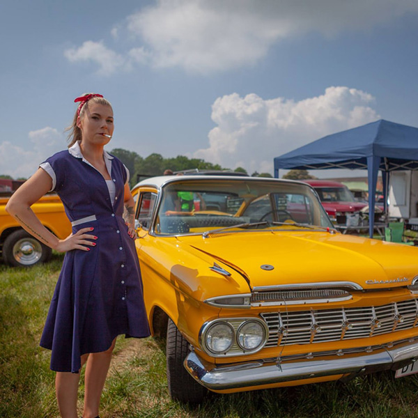 Gul amerikansk bil vid Timewinder Hundested, fotograferad utomhus under en klarblå himmel.