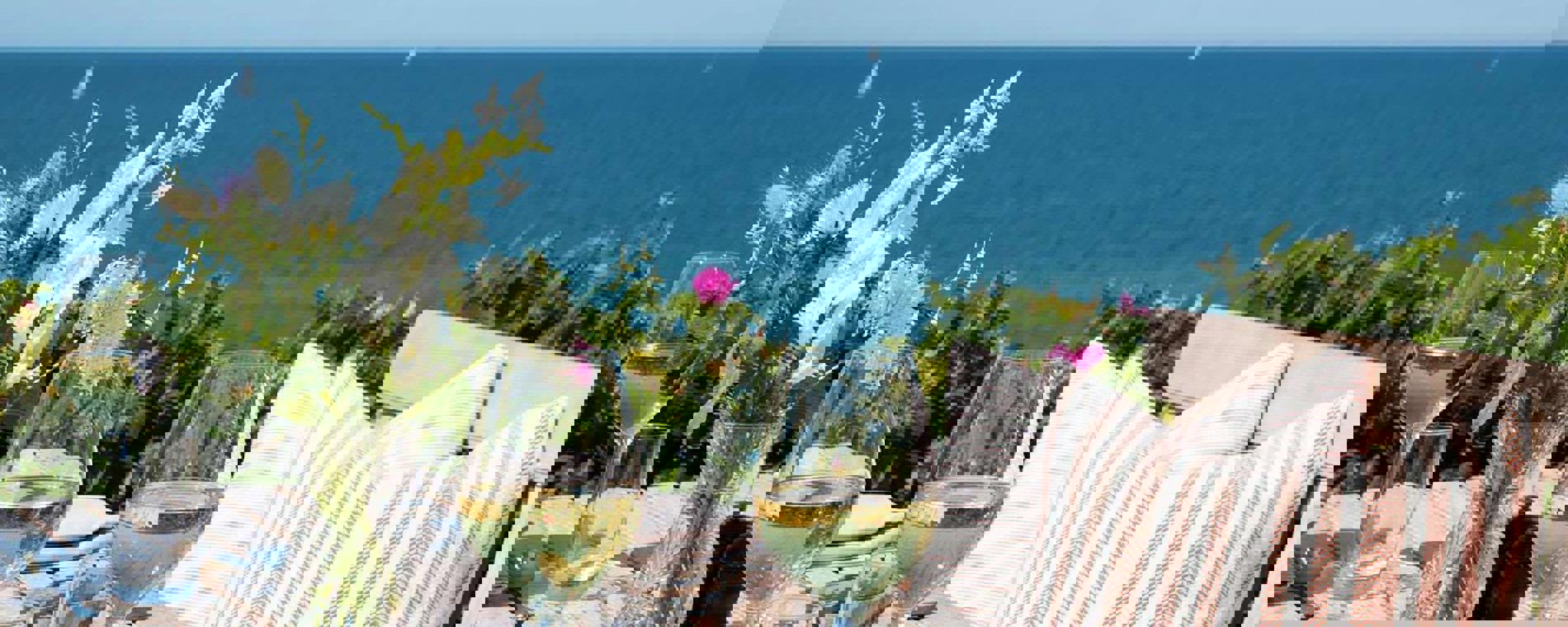 Ett bord dukat med blommor som blickar ut över havet.