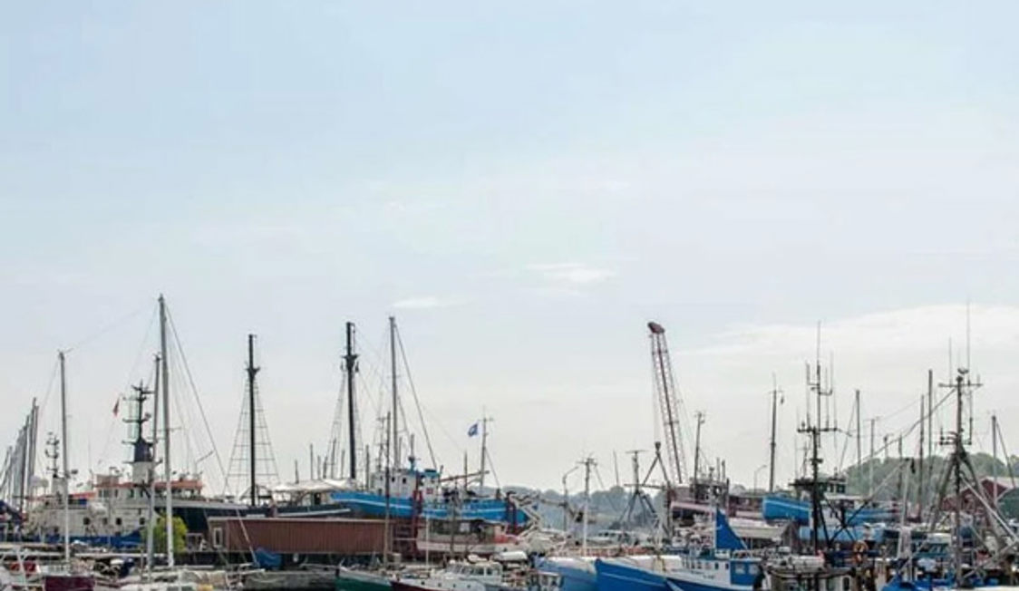 Gilleleje Hamn bord i marin miljö med fartyg i bakgrunden.
