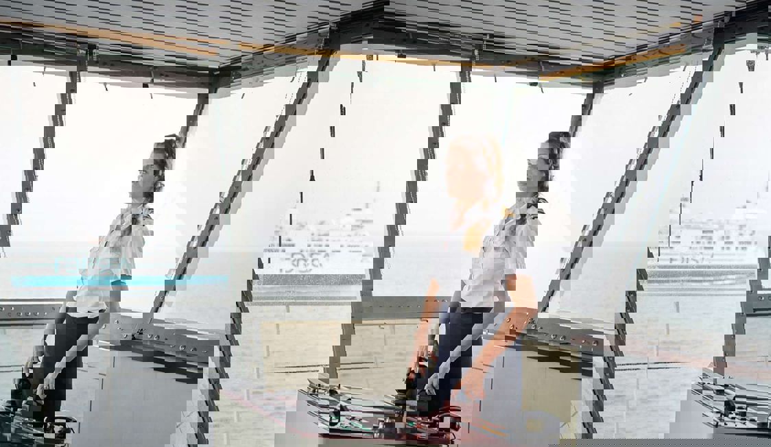 Anna seglar på öppet hav i uniform, bakom henne en Forsea-färja.