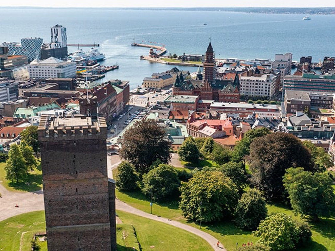 Udsigt fra Kärnan-tårnet over Helsingborgs bymidte mod havet, med historiske bygninger og parklandskab.