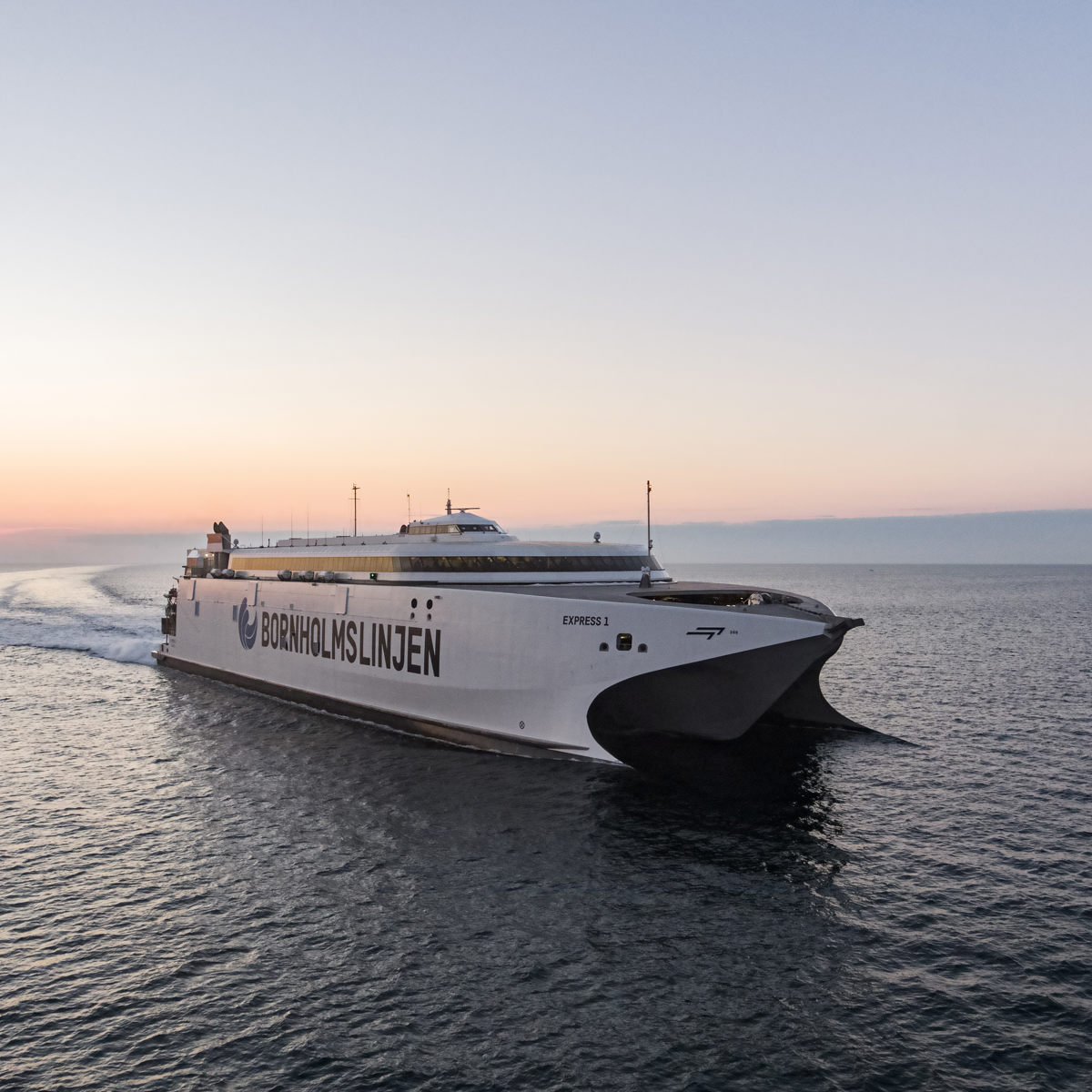 Bornholmslinjen ferry Express 1 sails on open sea at sunset from an aerial view.