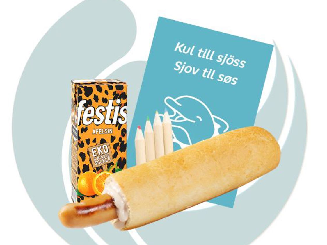 Barnmalet dryck Festis apelsin med sugrör, pølsehorn och färgkritor på blå delfinprydd bakgrund.