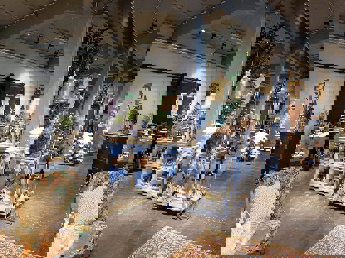 Shopping inde i Spritfabriken Slott med forskellige varer udstillet under butikens belysning.