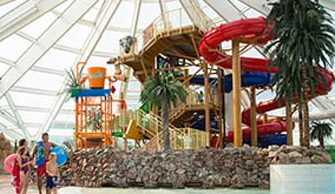 Inomhus vattenpark på Lalandia i Rødby med vattenrutschbanor och pool omgiven av tropisk inredning.