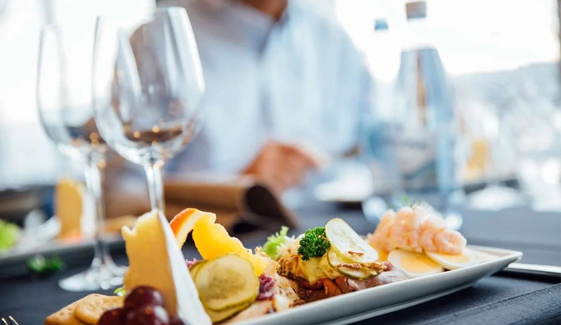 Gourmetfat med pålägg och frukt på ett elegant dukat bord i restaurangen under Forsea-konferensen.
