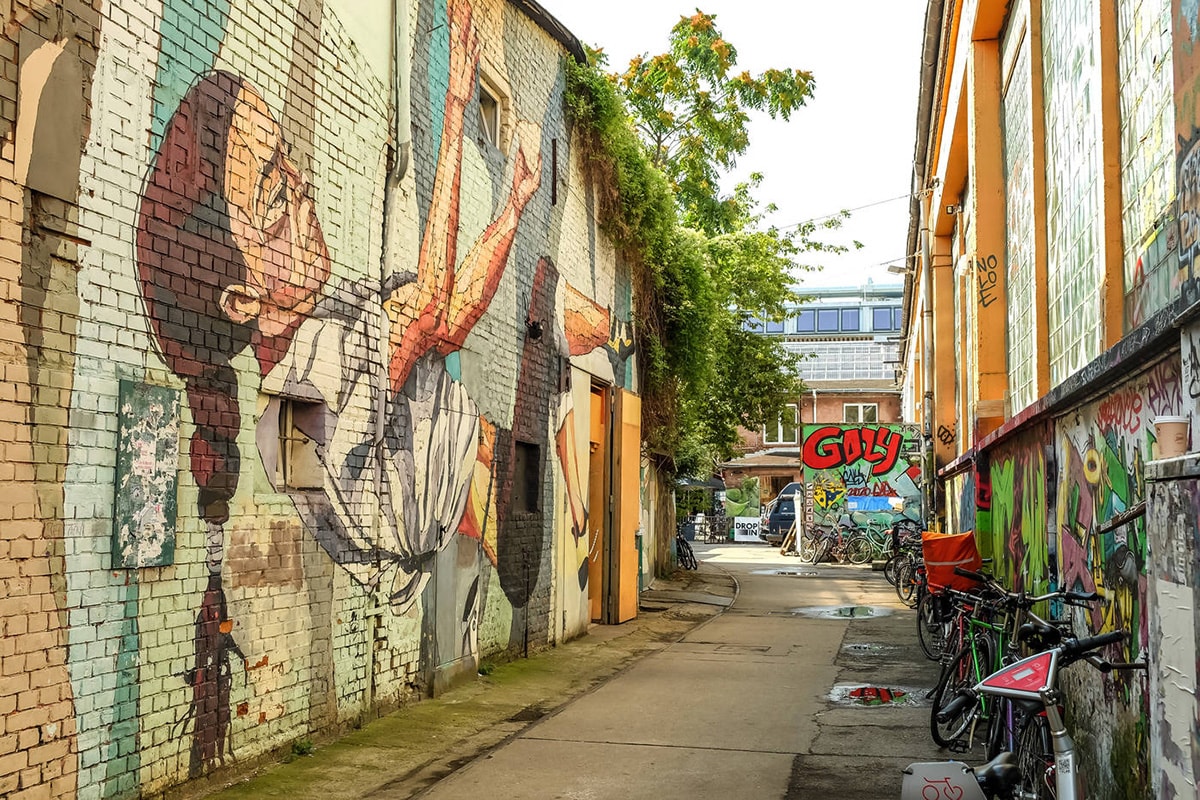 Gatukonst kan ses på väggarna på en liten smal gata i Berlin.
