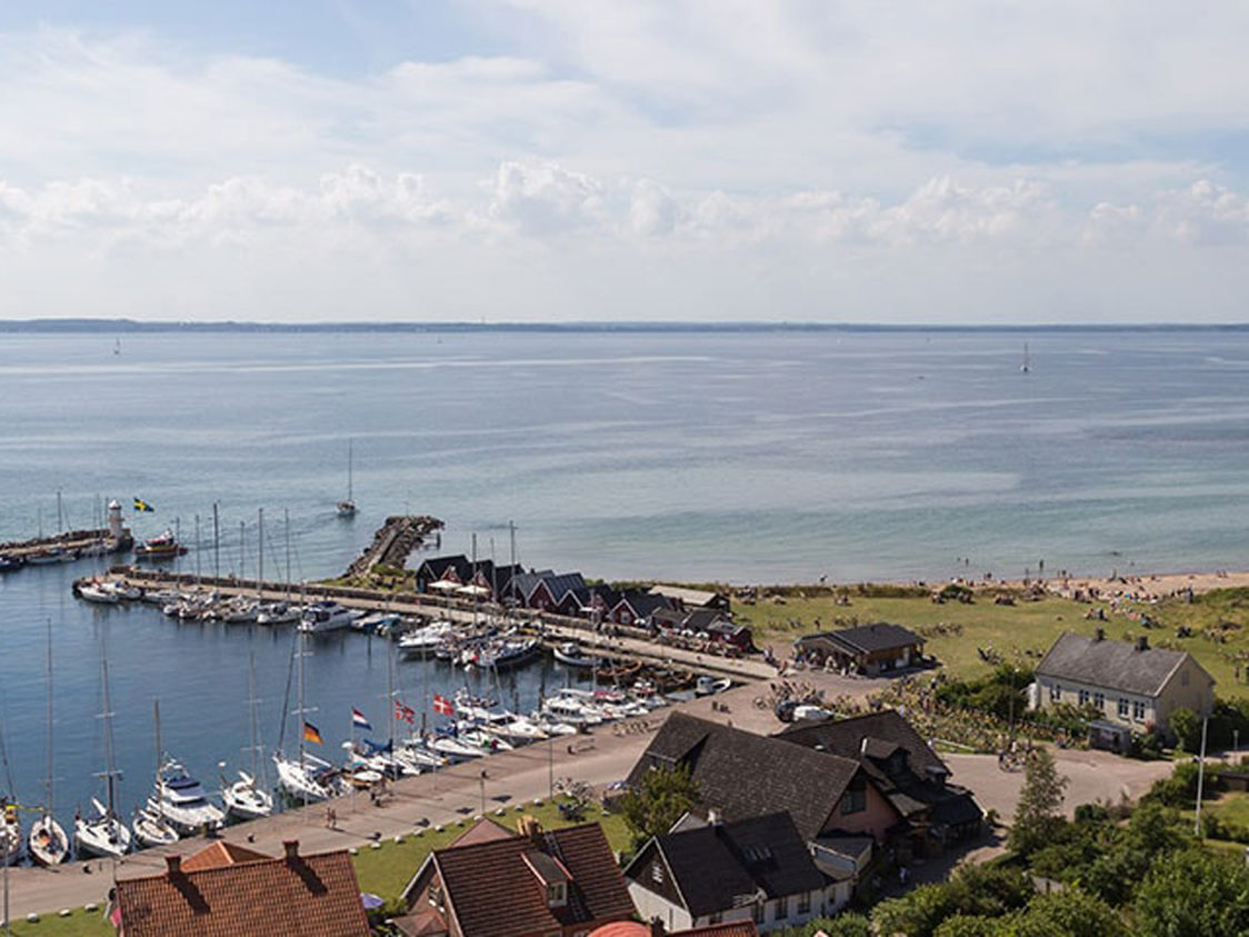 Havudsigt over sandstrand og lystbådehavn set fra fugleperspektiv en solrig dag i Skåne, Sverige.