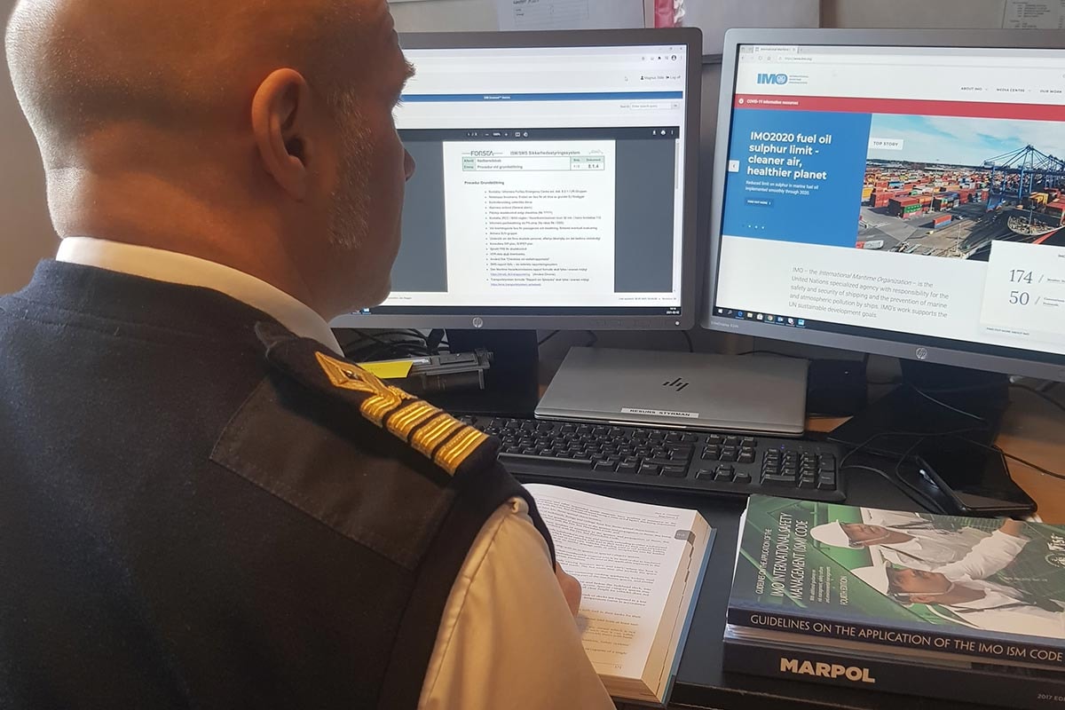 En man sitter vid en kontroll dator  x800, visad i sidoprofil med modernt användargränssnitt.