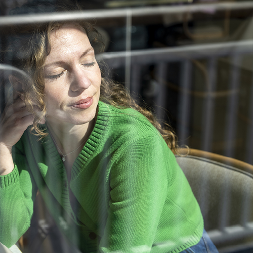 Kvinna med slutna ögon vid färjefönstre