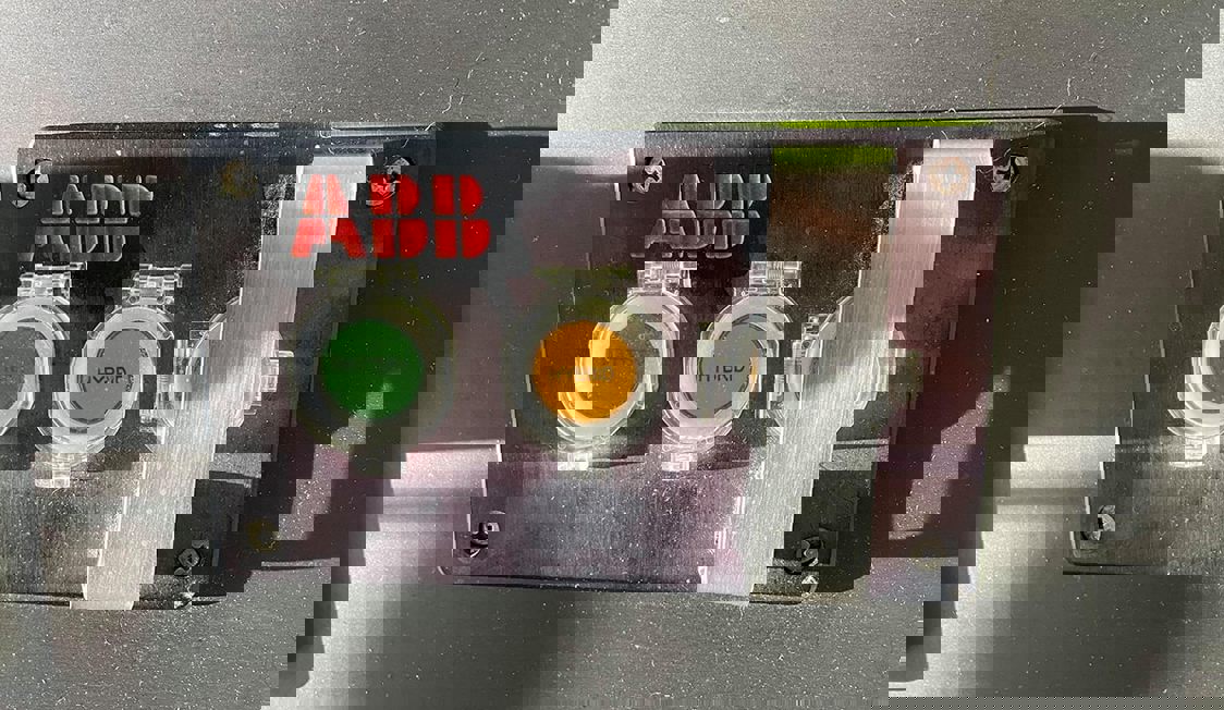 Batteridriven ABB-knapp i närbild med strukturerad design och tydliga funktioner.