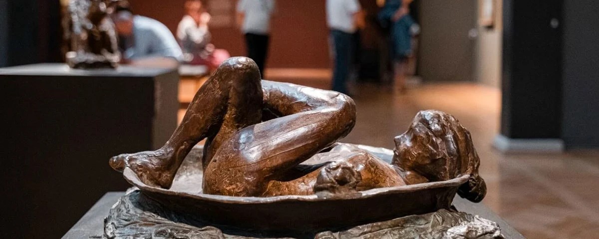 Kvinnoskulptur i brons från Glyptoteket visar fransk konst i detalj, med fokus på kroppens linjer i en utställningshall.