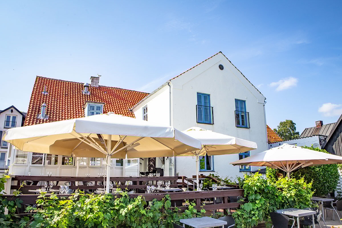 Fasaden på Restaurant Plain i solsken och blå himmel.