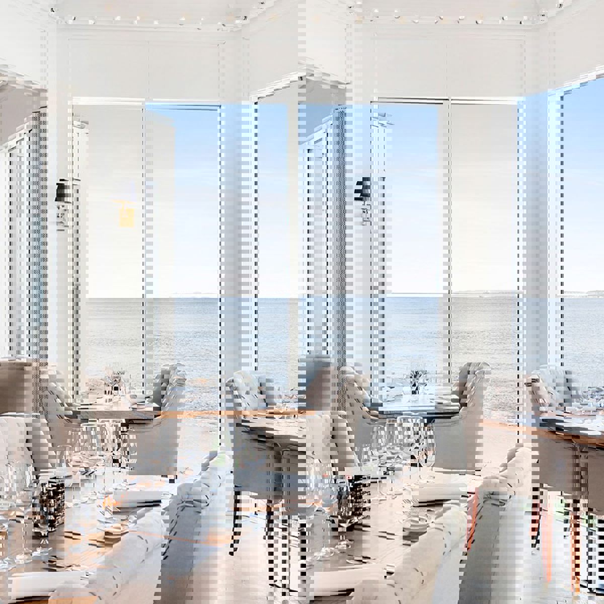 Utsikt över havet från Marienlyst från insidan av ett mycket ljust rum med bord och stolar i modern stil.