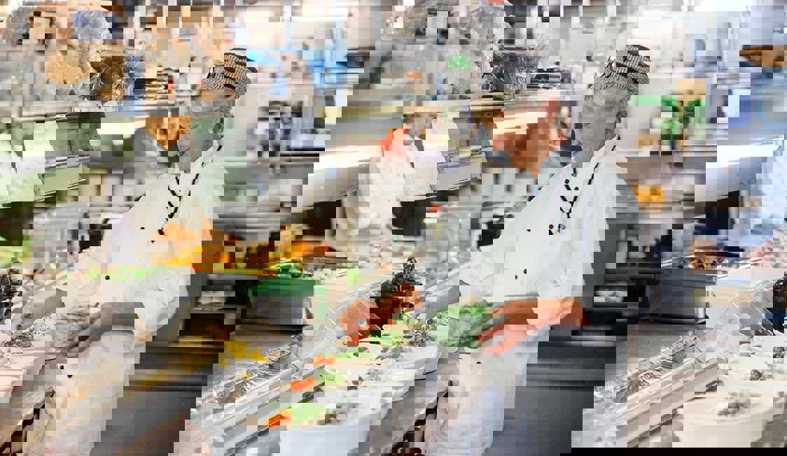 Kock på Öresundslinien ses förbereda mat i köket.