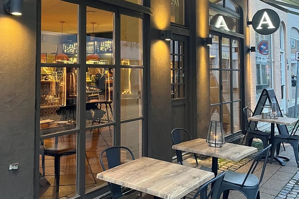 Restaurang Appetit med mysig uteservering och upplysta fönster som speglar interiören och dekorationerna.