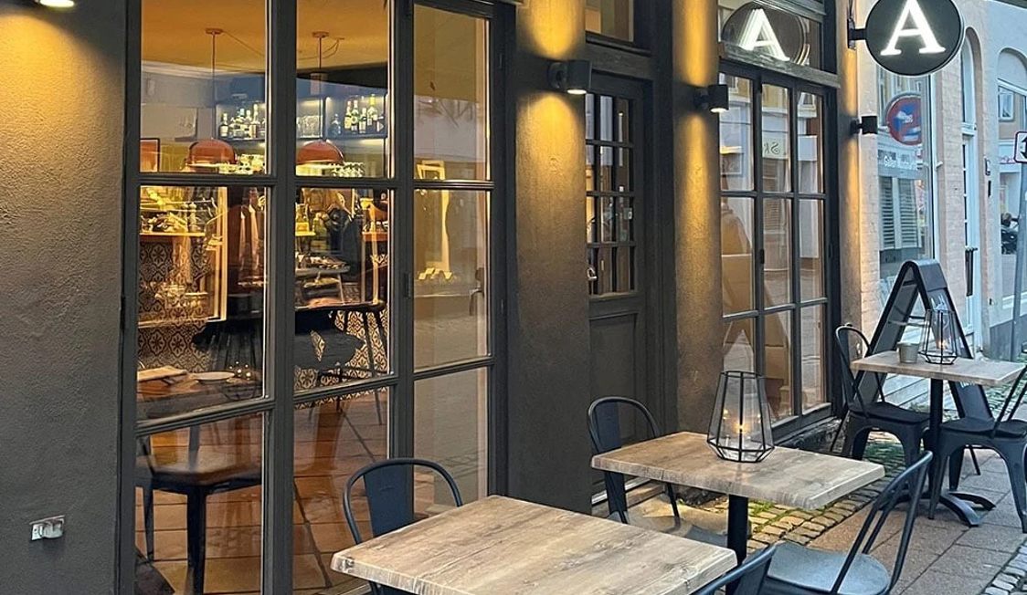 Restaurang Appetit med mysig uteservering och upplysta fönster som speglar interiören och dekorationerna.