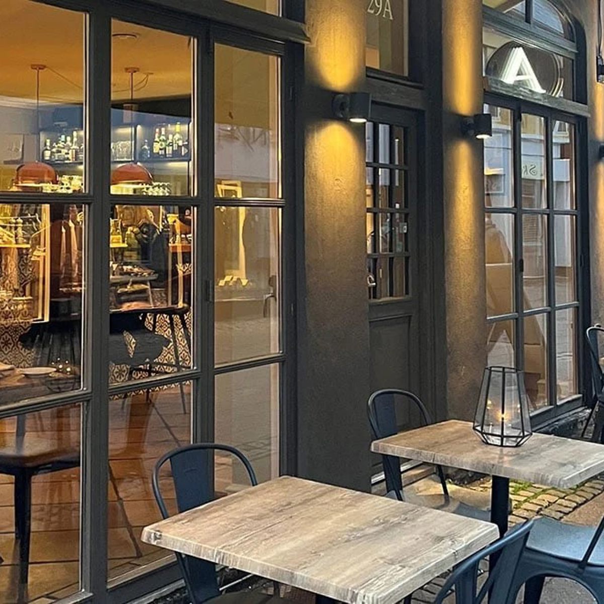 Restaurang Appetit med mysig uteservering och upplysta fönster som speglar interiören och dekorationerna.