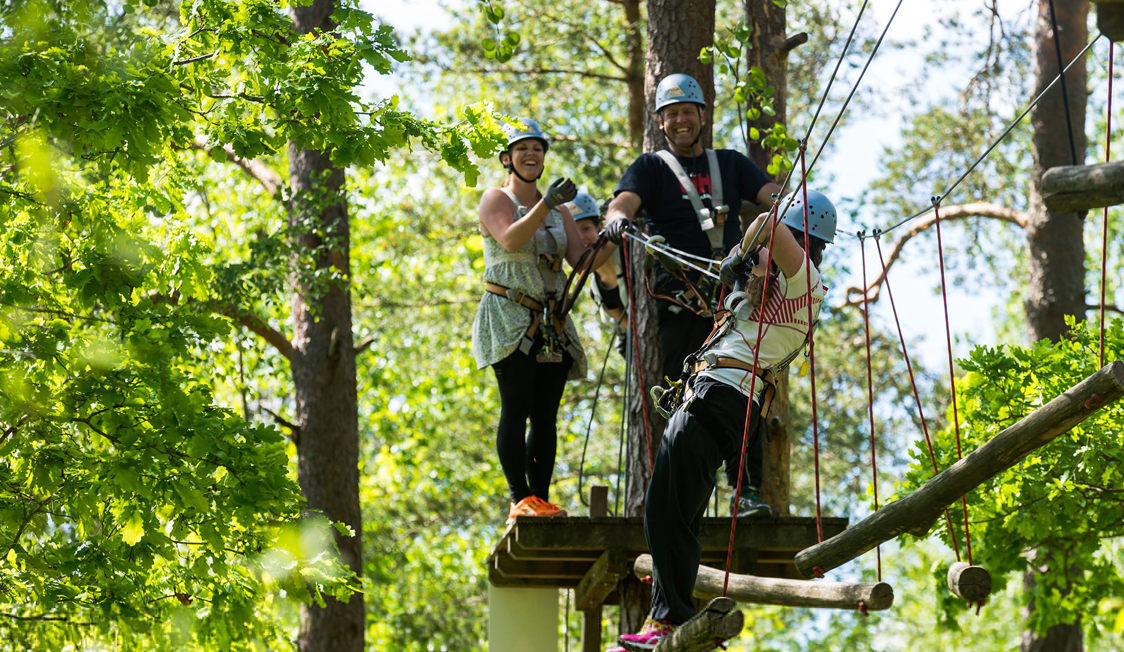 En person skriver på en bærbar computer med en kop kaffe ved siden af på et træbord.