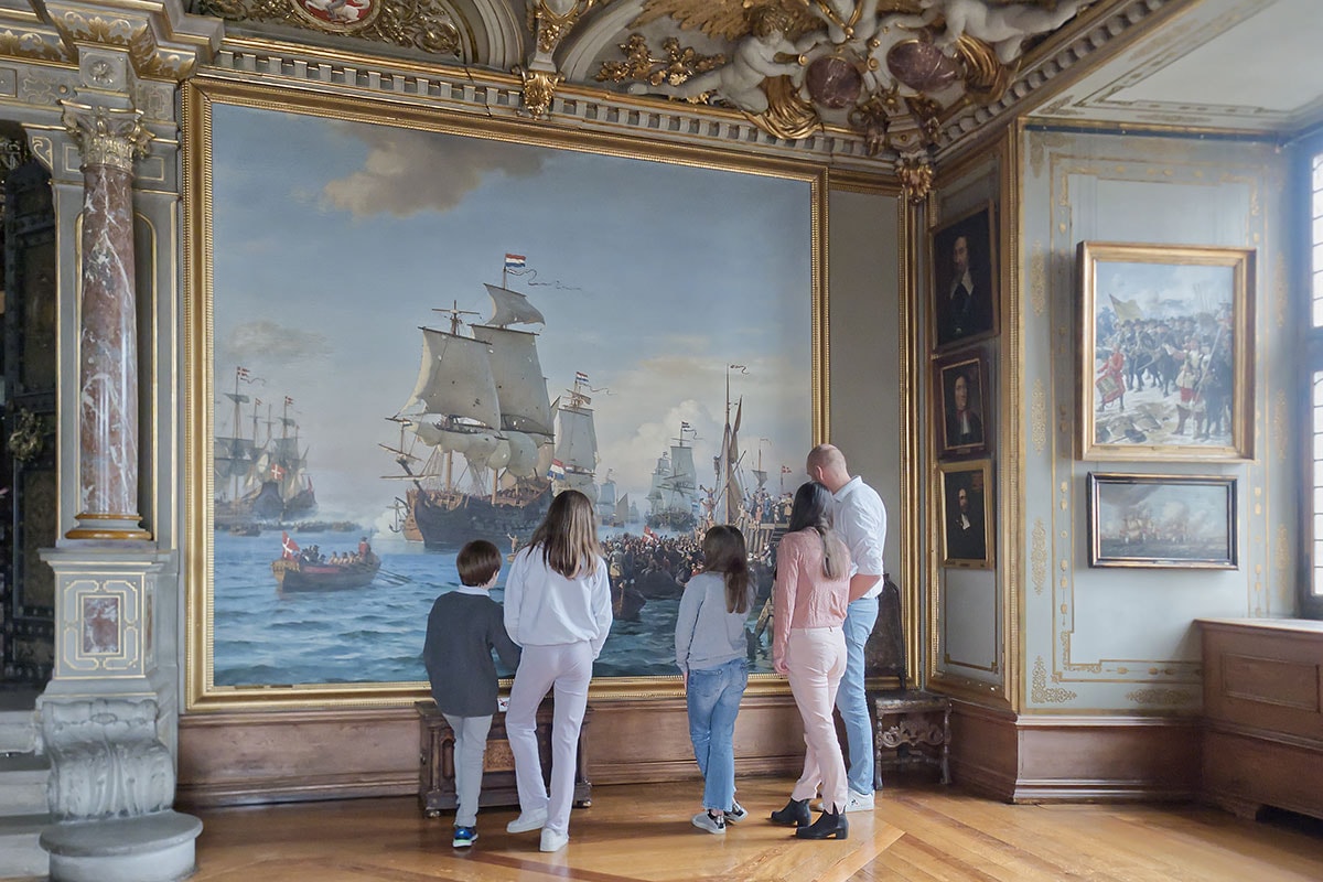 Familj på Frederiksborgs slott inspekterar konstverk.