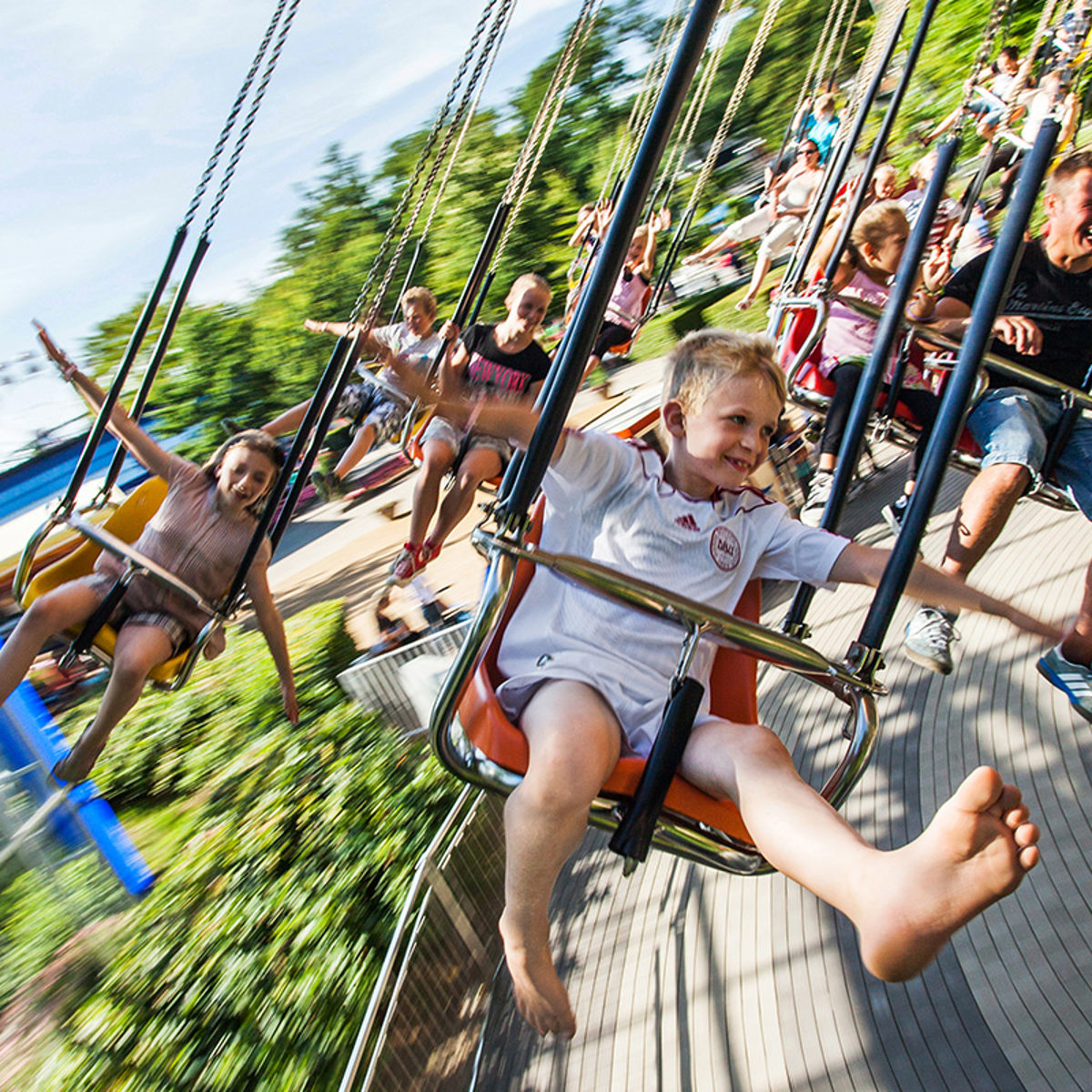 Børn ses i gynger svinge rundt i forlystelse i Friheden.