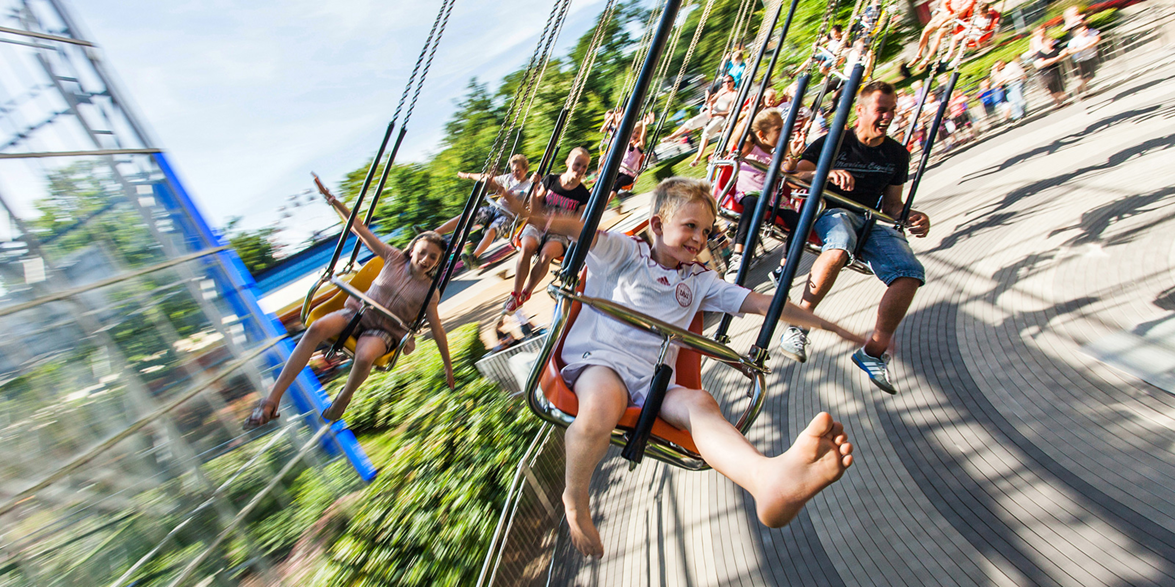 Børn ses i gynger svinge rundt i forlystelse i Friheden.