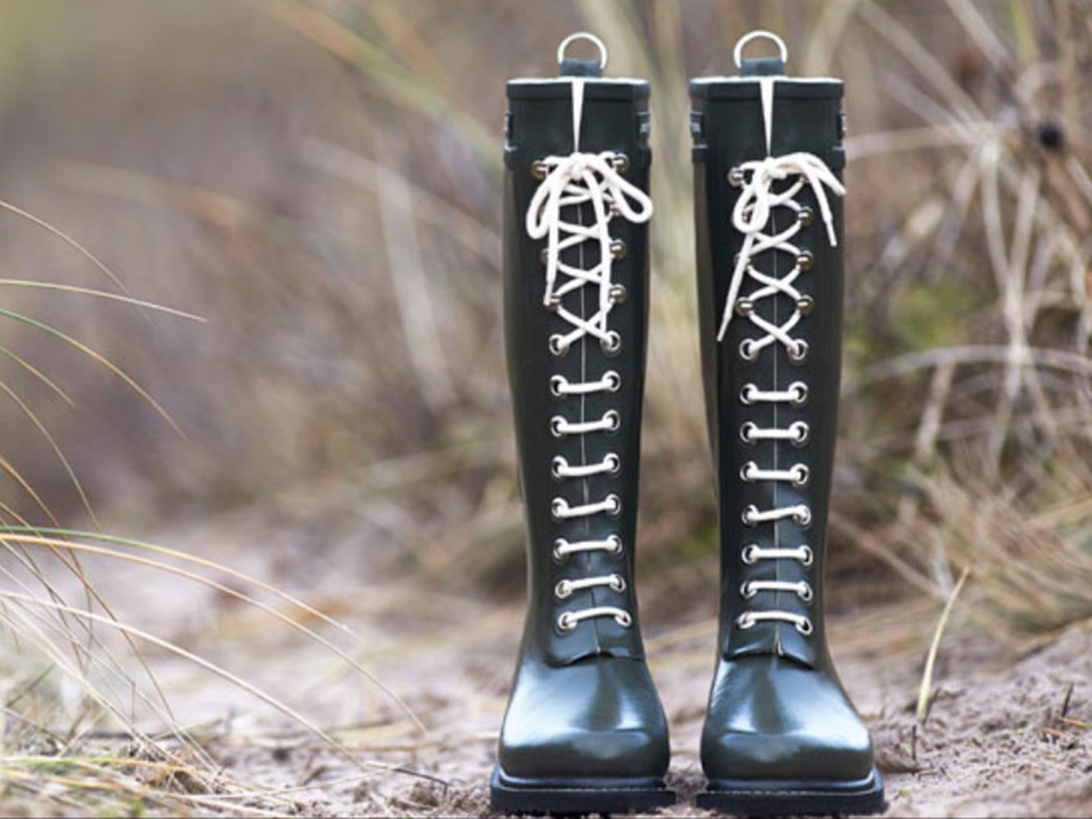 Klassiska gröna stövlar av Ilse Jacobsen med vita snören, idealiska för promenader i naturen.