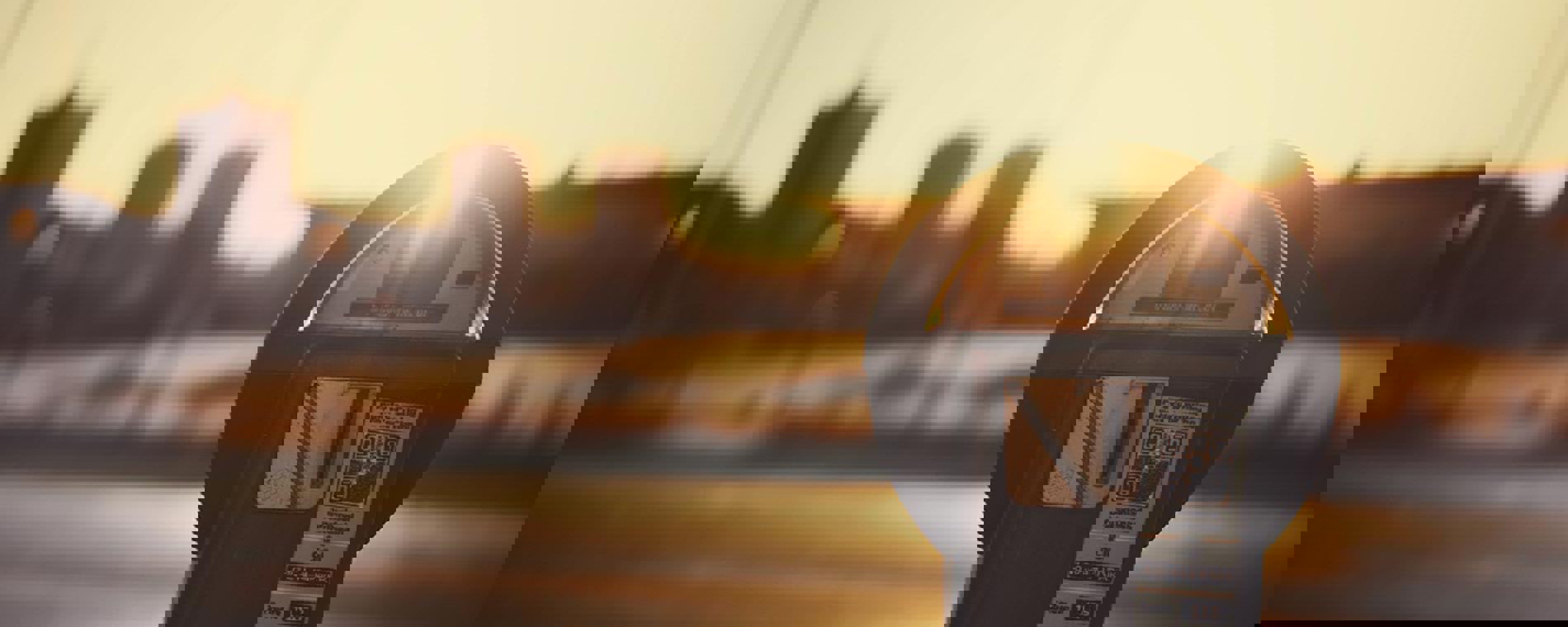 Närbild av en parkeringsautomat i solnedgångens ljus.