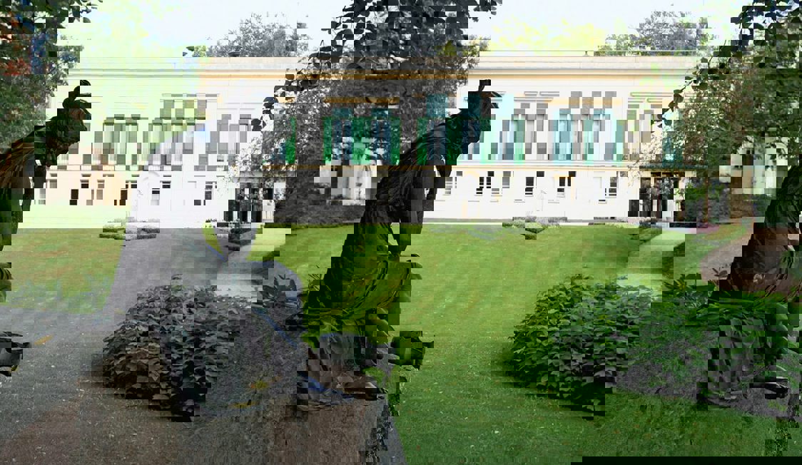 En staty står i förgrunden i en park i Berlin Potsdam.