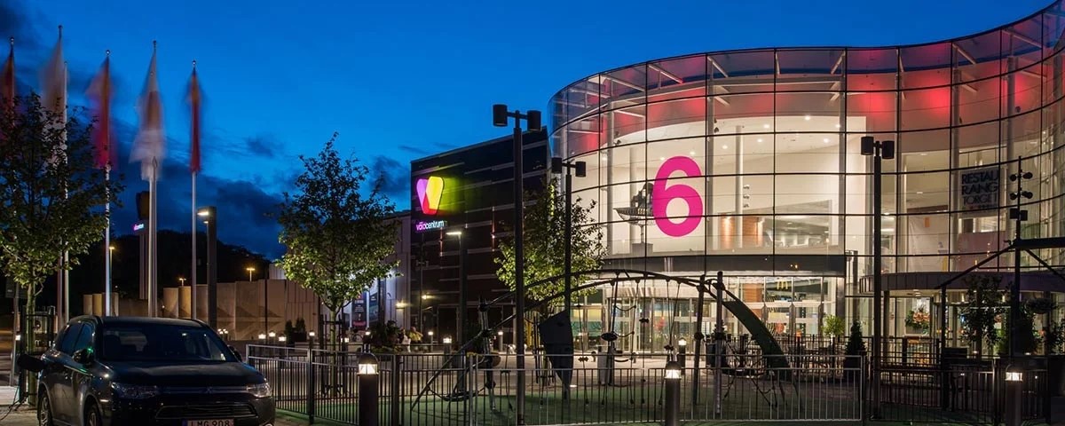 Kuppelformet biografindgang med stort pink 6-tal oplyst om natten ved Vejle biocenter.