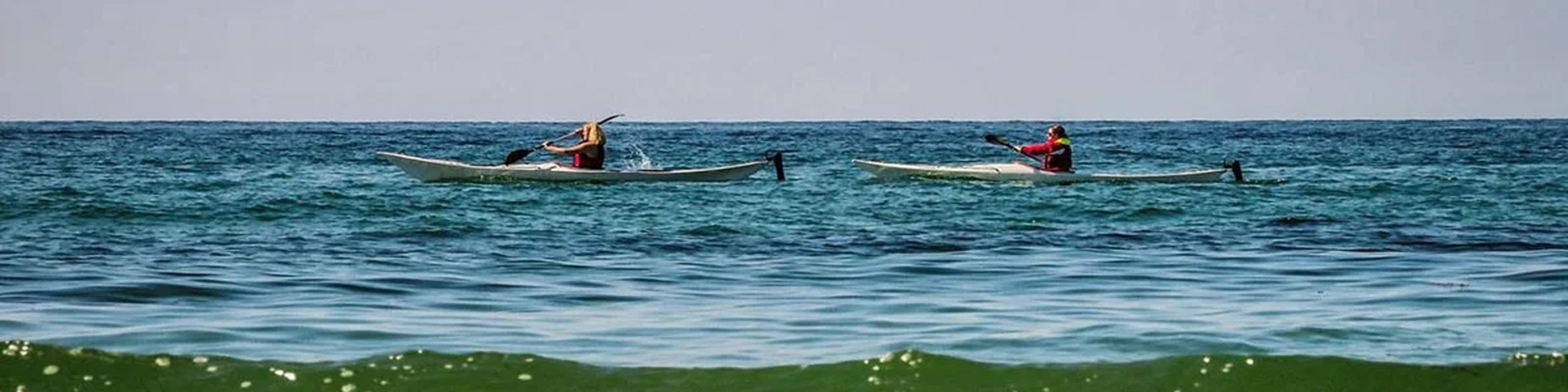 Två personer paddlar Nordsjälland Liseleje kajak på öppet hav i solsken.