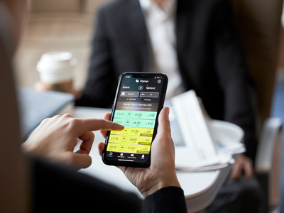 Eine Person benutzt ein Smartphone, um eine Fährverbindung in der Molslinjen Business Lounge zu buchen.