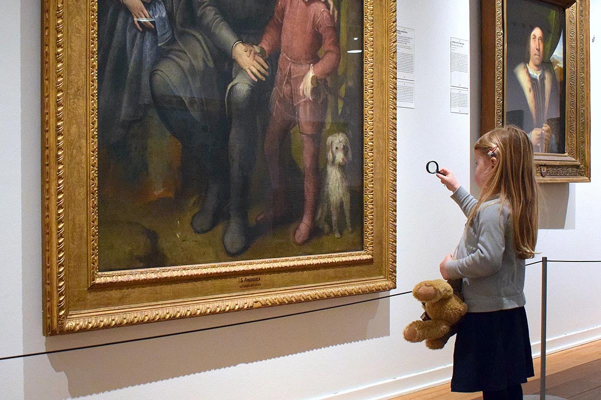 En kvinna tittar på målningar inne på Nivaagaard.